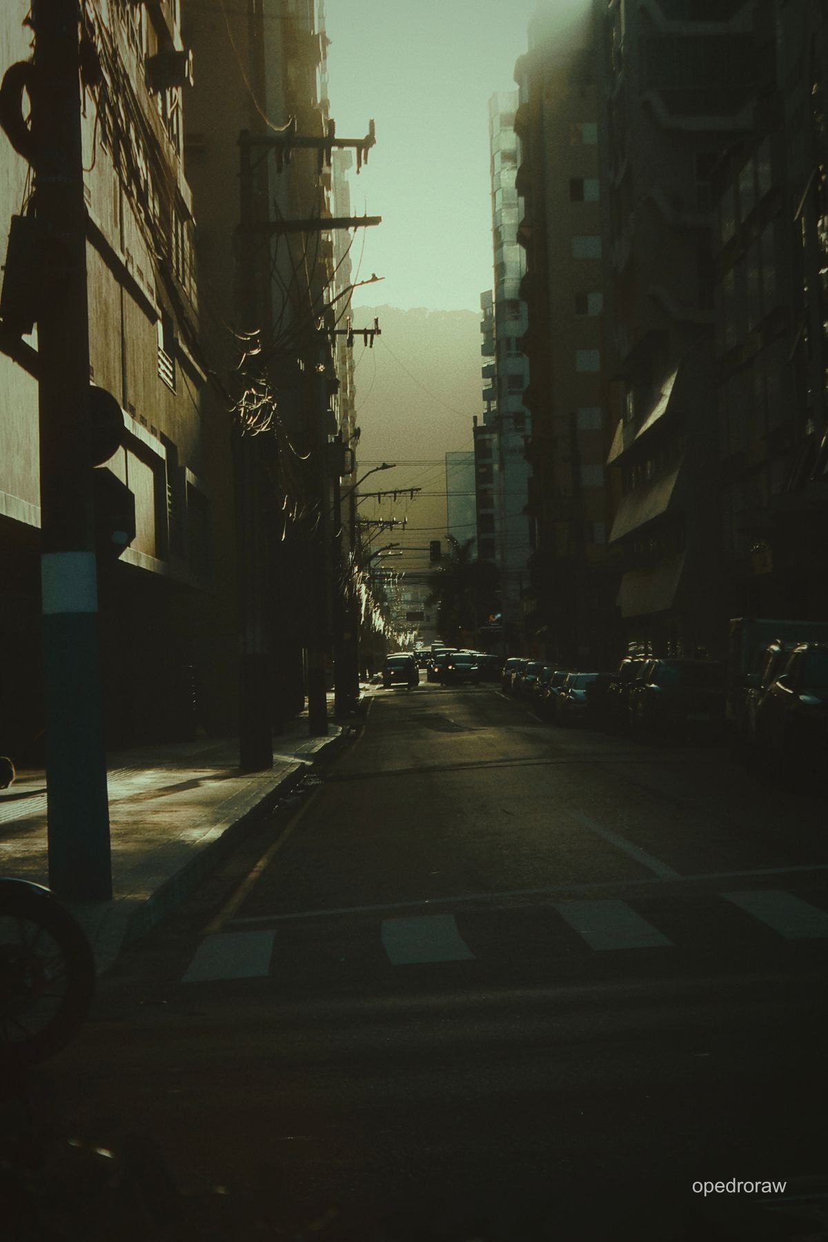 Luz dourada entre os prédios de uma rua