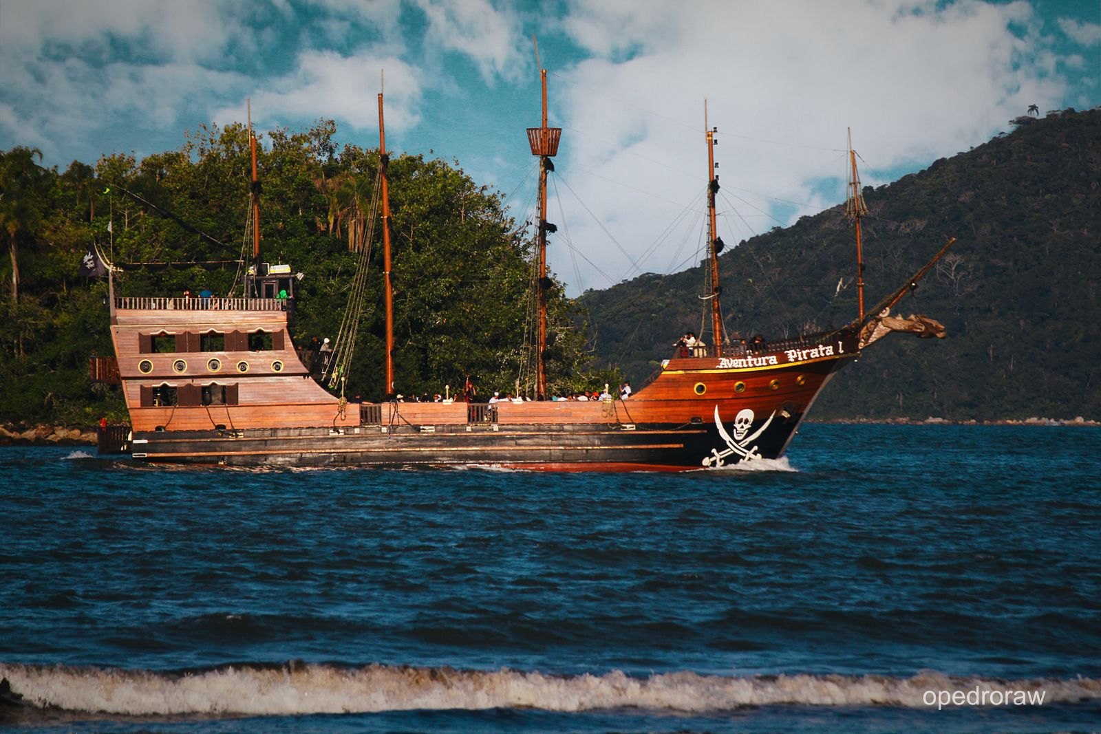 Barco de madeira navegando junto à costa