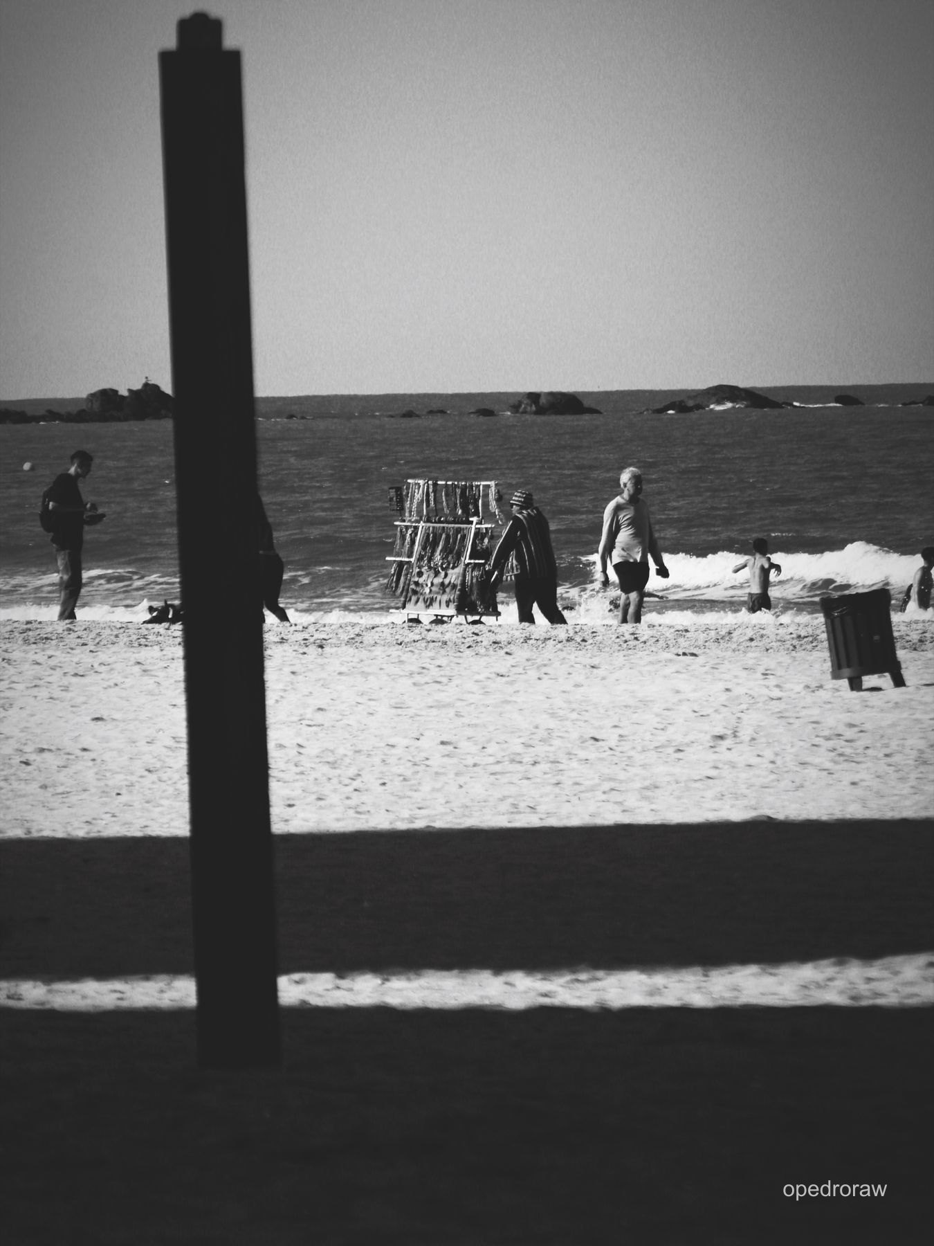Pessoas na praia em fotografia em preto e branco